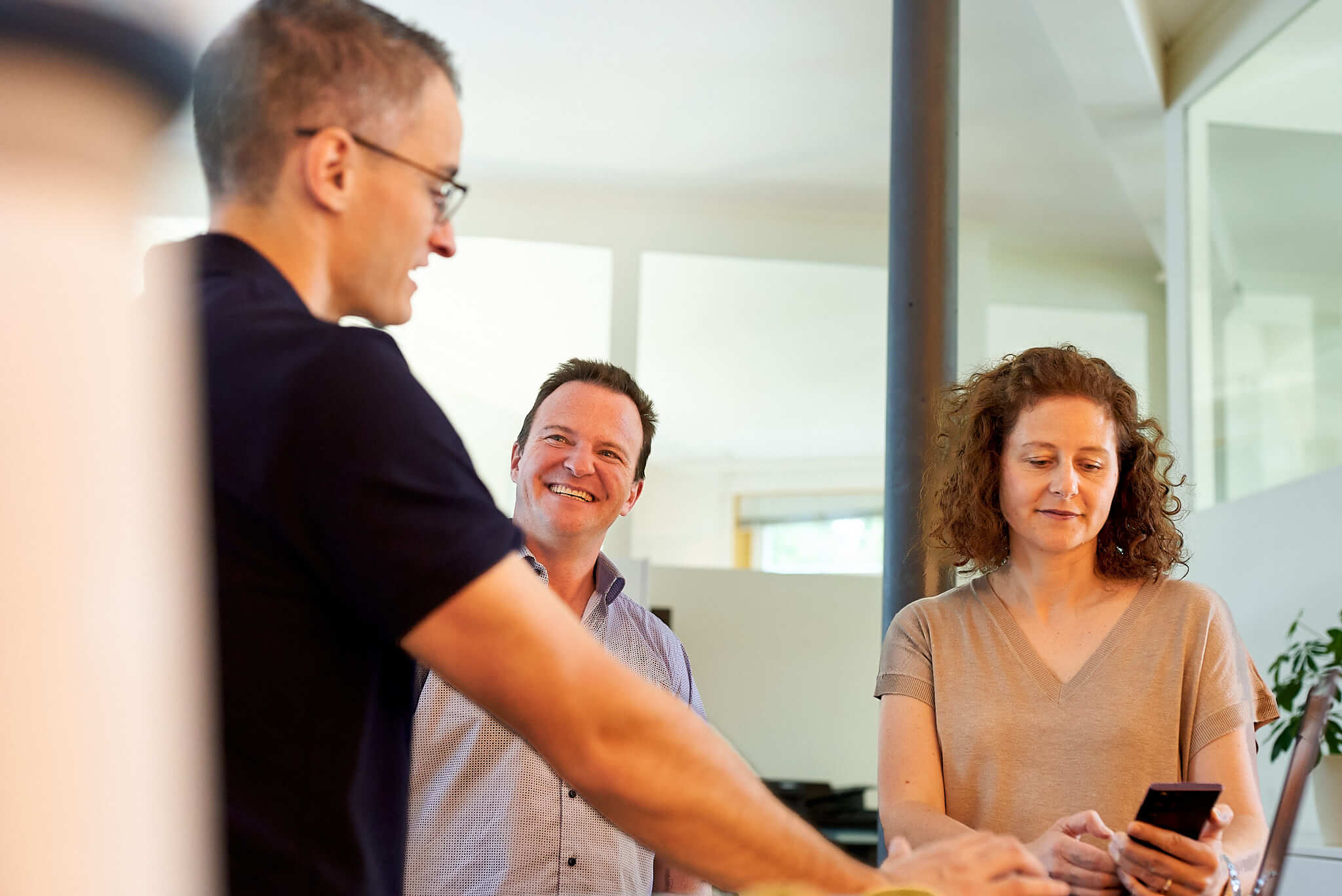 Javier, Patrick und Sandra stehen an einem Tisch